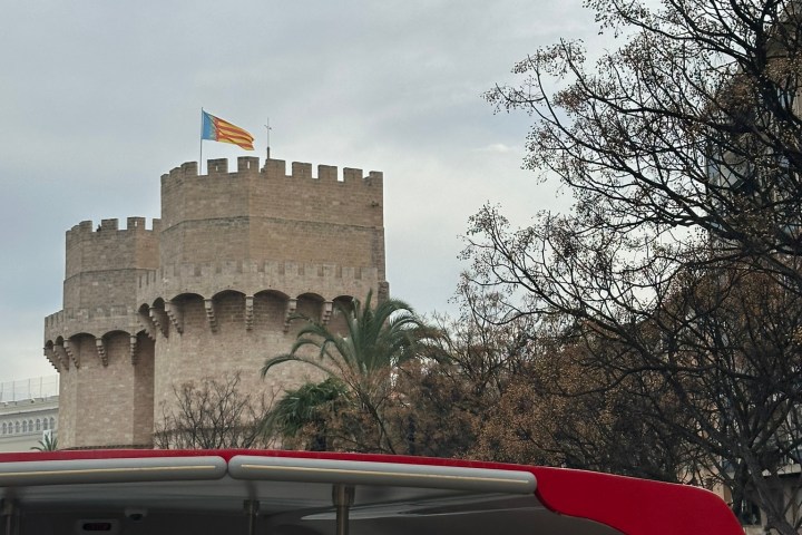 a passenger bus that is parked on the side of a building