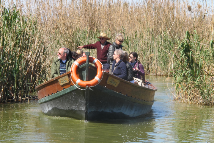 a group of people riding on the back of a boat in the water
